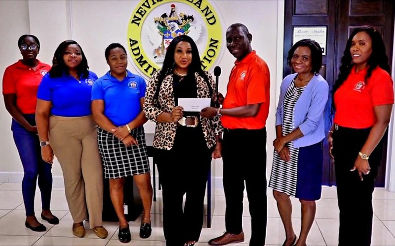 Ministry of Tourism Nevis Celebrates Community Support Through Cheque Handover to Mrs. June Queeley